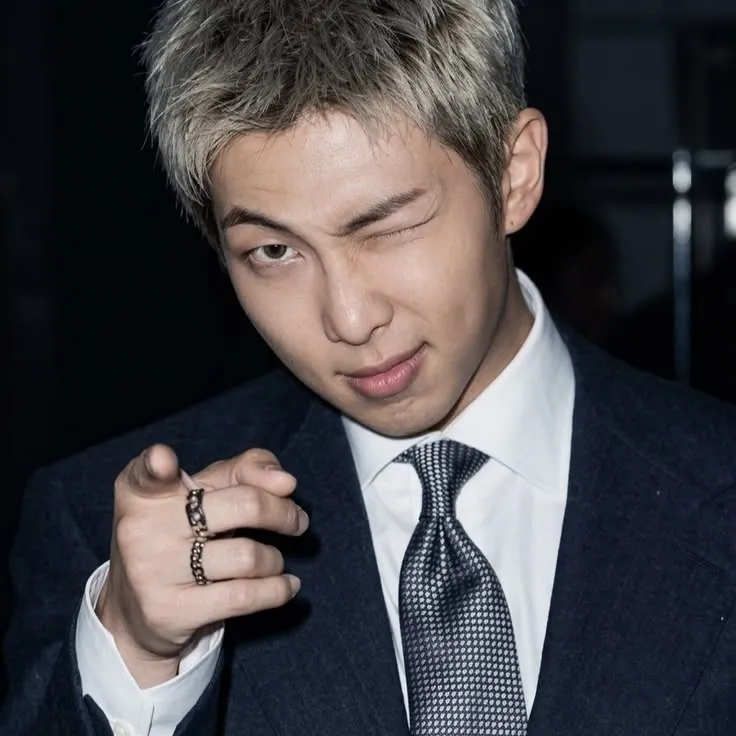 Multilingual Kim Namjoon focusing on chat IA tasks, neural network core visible in background.
